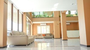 A spacious interior with a high ceiling, large windows, and a central seating area. - VELIN Pattaya Hotel-Family 2 (Nong Prue Subdistrict)