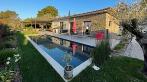 A house with a swimming pool, a covered patio, and a garden with a lawn and potted plants. - Contemporary Villa with Unobstructed View & Pool (Éguilles)
