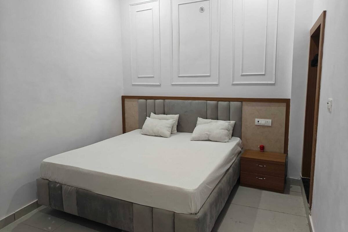 A bedroom with a bed, nightstand, and a door.