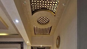 A hallway with a sofa, a television, and a decorative ceiling. - شقة فندقية لعشاق الذوق الرفيع Luxury Flat In Miami with panoramic sea views (Alexandria Governorate)
