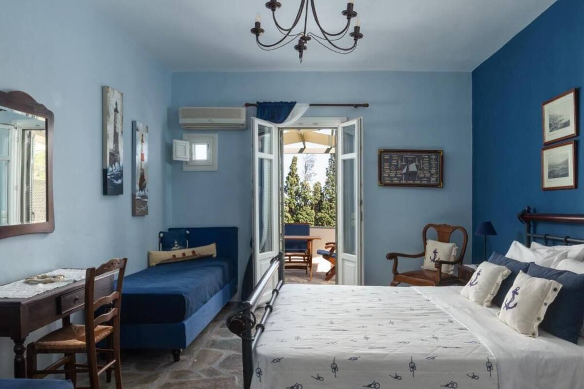 A bedroom with a bed, a desk, a chair, and a window.