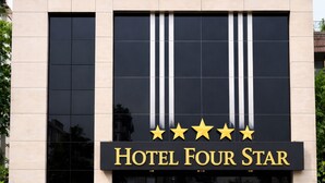 Rakennuksessa on kyltti, jossa lukee ”HOTEL FOUR STAR”, ja sen yläpuolella on viisi tähteä.