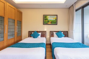 A hotel room with two beds, a painting on the wall, and a large window with curtains. - Koaniva The Ocean Villa Da Nang Luxury (Da Nang)