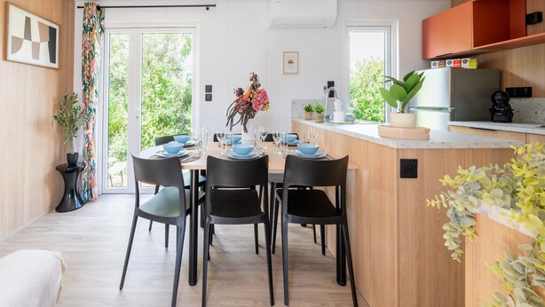 Una cocina moderna con horno integrado, cafetera y refrigerador.