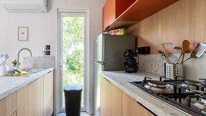 Una cocina moderna con estufa integrada, un lavamanos y un cubo de basura.
