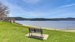 Un banco junto a un lago, con vistas claras al agua y colinas lejanas.