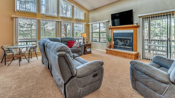 A spacious living room with a fireplace, large windows, a television, and a dining area. - 1 Mi to Alto Lake! All-Season Base w/ Mtn Views (Alto)