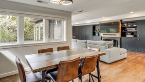Eine moderne Küche mit dunklen Schränken, einem eingebauten Backofen und einem großen Fenster.