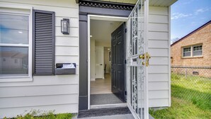 Een huis met een open voordeur, een brievenbus en een klein portaal.
