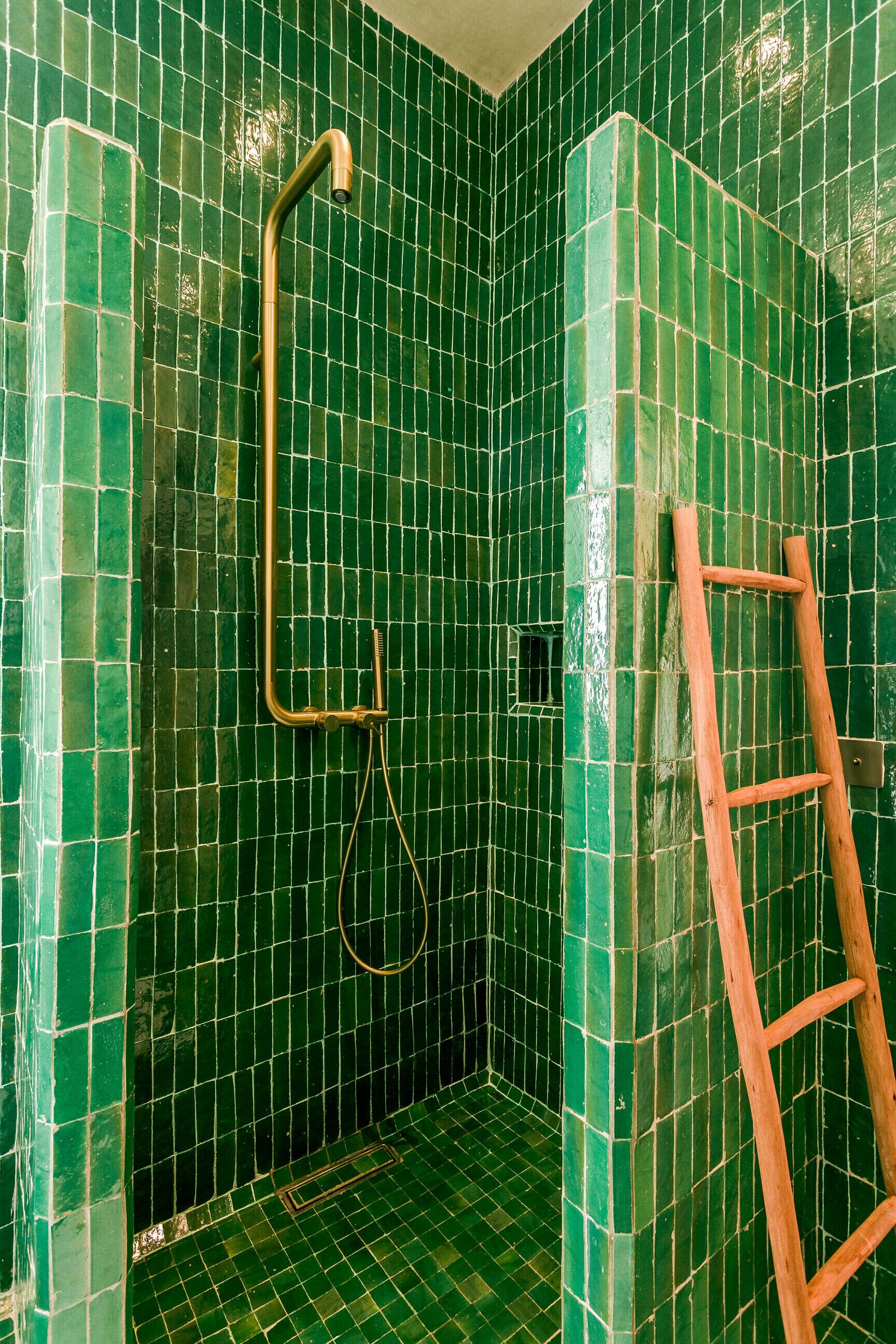 Un baño pequeño con revestimiento de azulejos y una escalera de madera.