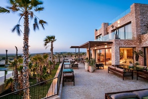 A modern outdoor patio with seating, a pool, and a view of the landscape. - Zayyna (Ghazoua)