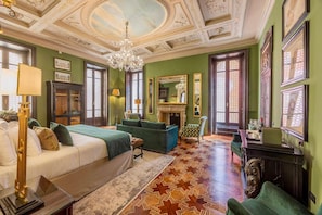 A room with a bed, a sofa, a chair, a fireplace, and a chandelier. - PALAZZO TREZZA VERONA Preferred Hotels & Resorts (Verona)