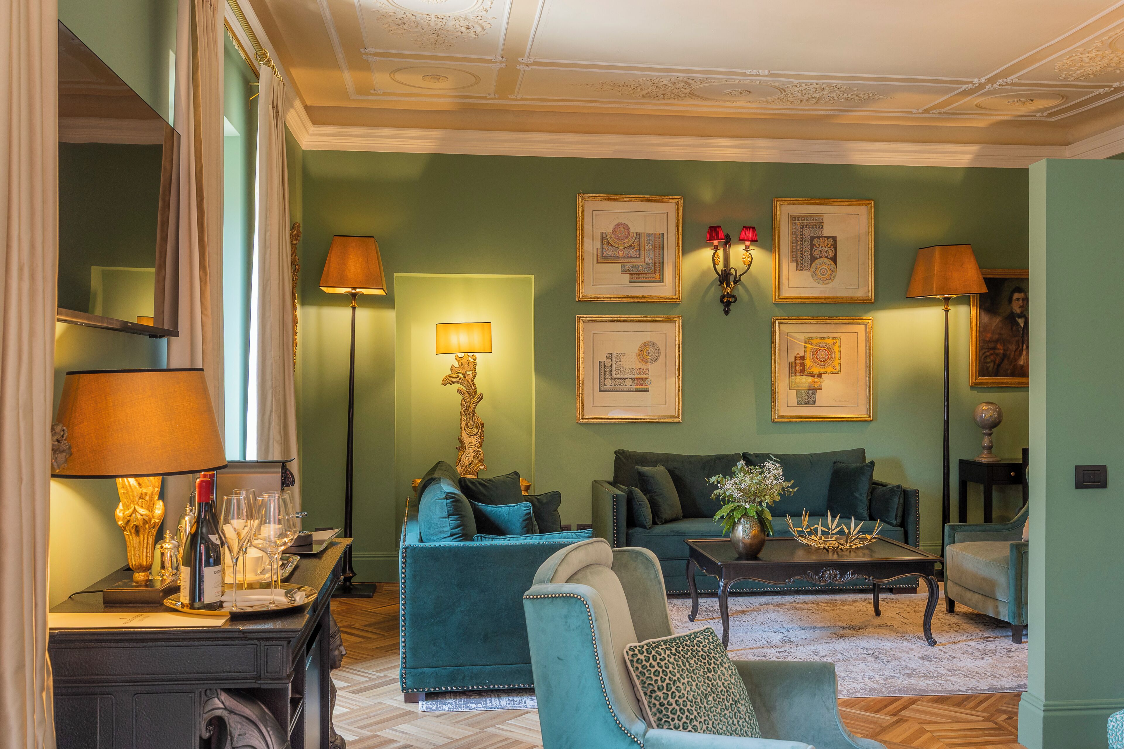 A room with a sofa, armchairs, a coffee table, and wall-mounted lamps.
