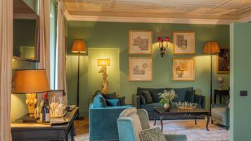 A room with a sofa, armchairs, a coffee table, and wall-mounted lamps.