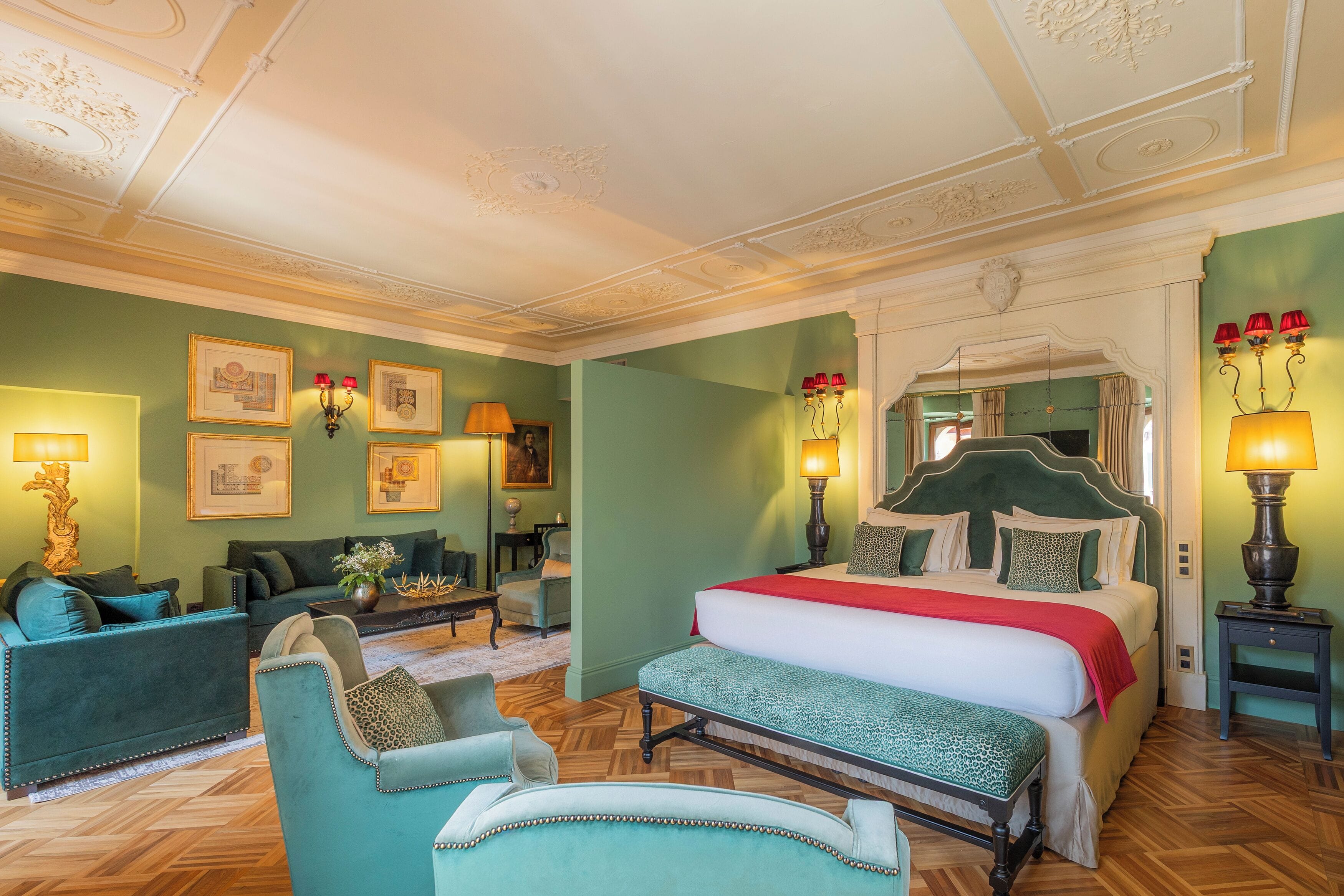 A room with a bed, two armchairs, a sofa, and a coffee table.
