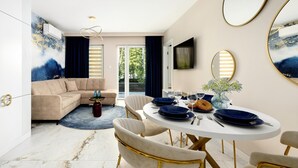 Un espace repas moderne avec une table ronde, des chaises et un grand miroir.