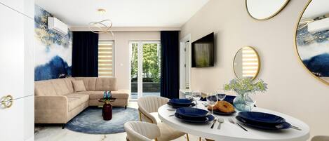 A modern dining area with a round table, chairs, and a large mirror.