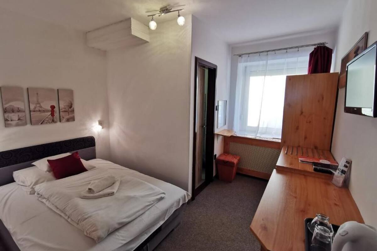 Una habitación de hotel con cama, escritorio, ventana y puerta.