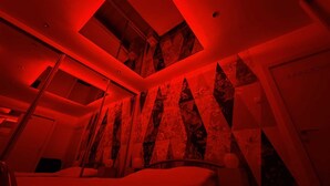 A room with a sloped ceiling, a bed, and a large window. - House of Mirrors Belgrade (Beograd)