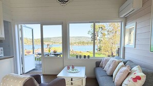 Una habitación acogedora con un sofá, una mesa y vistas a un lago.