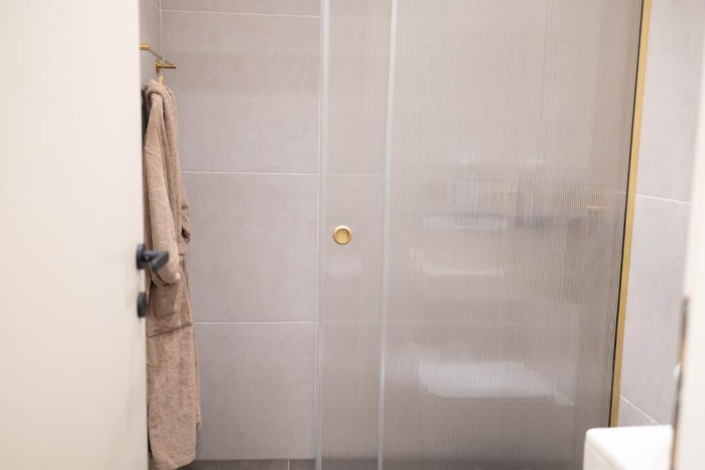 Un baño con ducha, toallero y retrete.