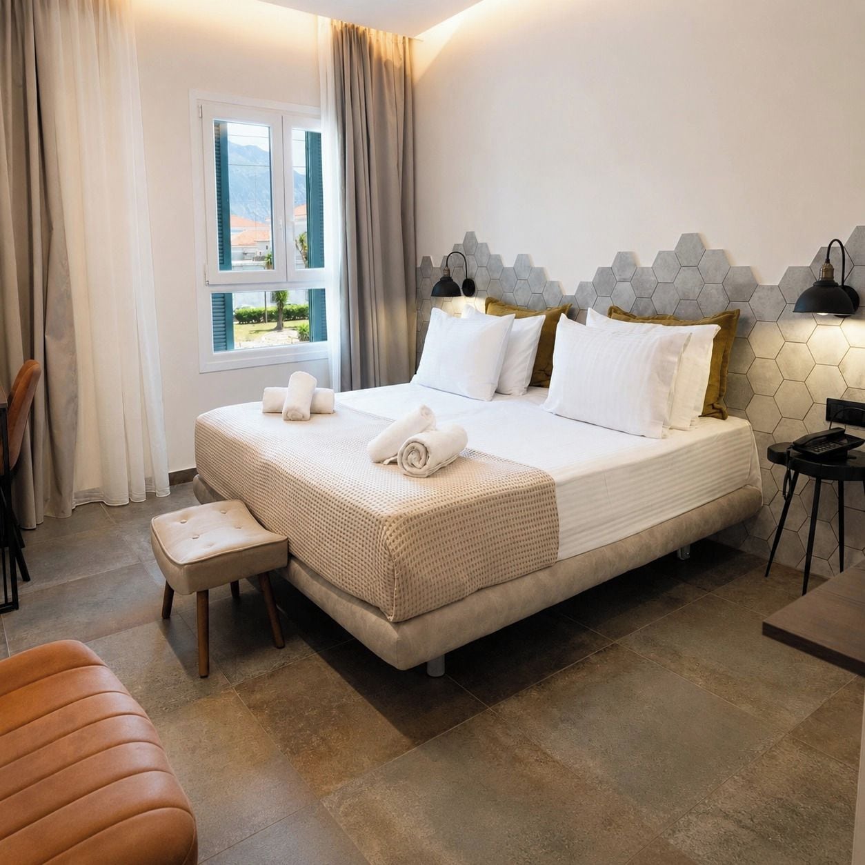 Una habitación de hotel con una cama, una ventana, una silla y una mesita de noche.