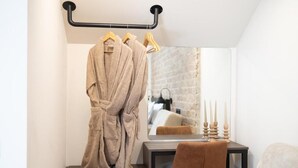 A bathroom with a towel rack holding two towels, a mirror, a sink, and a chair. - ASO Hotel - Historic Raisin Warehouse 1928 (Kalamata)