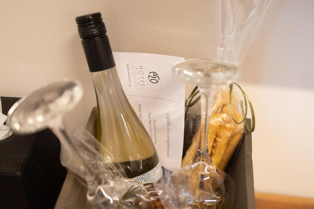 Een fles wijn, een glazen fles en een zak brood in een doos.