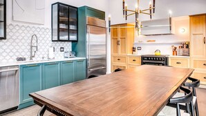 A modern kitchen with a central island, pendant lighting, and a skylight. - Greenbank Horizon Home | Water Views (Greenbank)