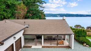 A house with a covered patio, a garage, and a view of a lake. - Greenbank Horizon Home | Water Views (Greenbank)