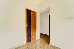A hallway with a wooden door marked with the number 111, leading to a room.