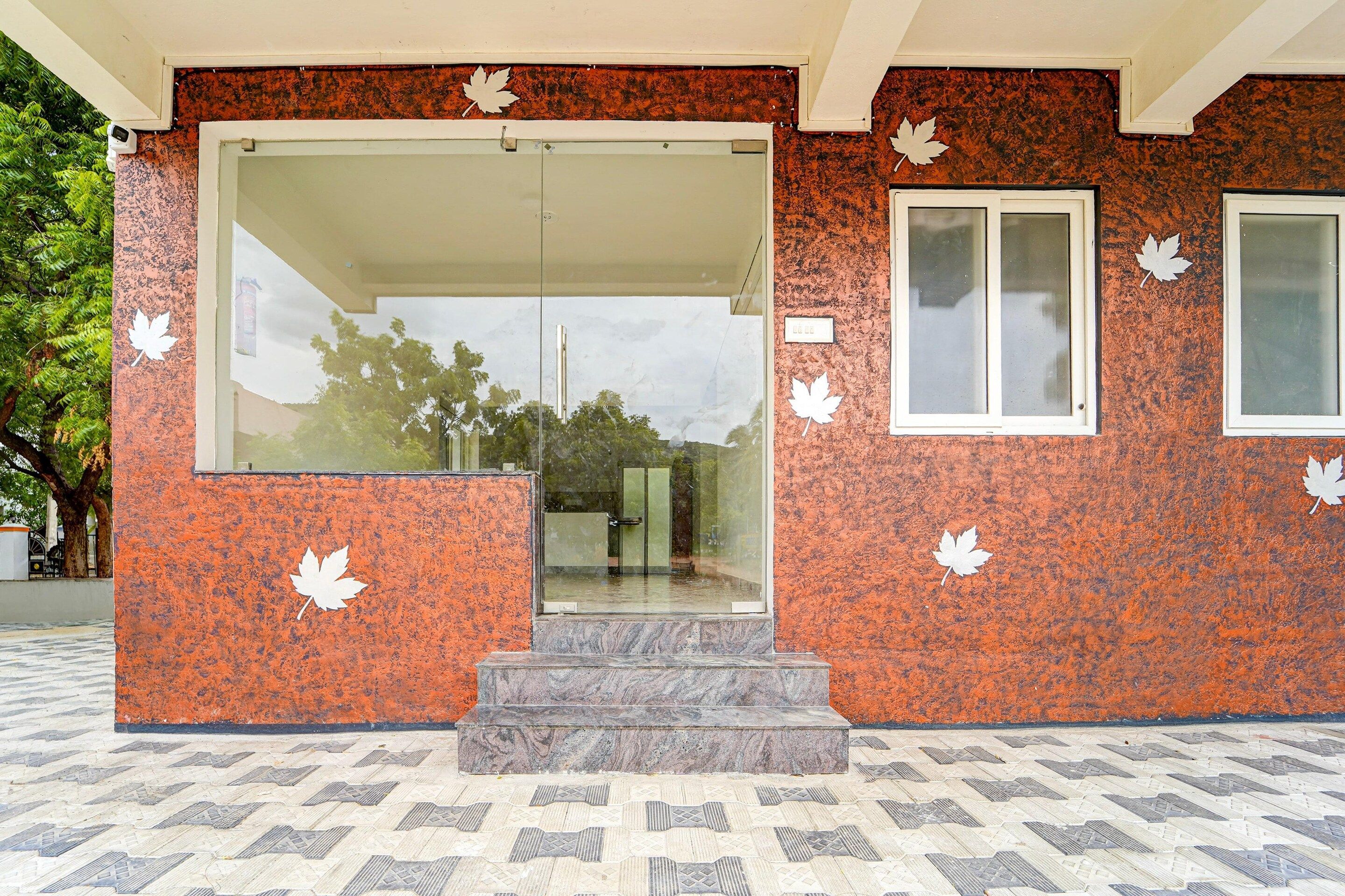 A building entrance with a glass door, a small window, and a set of steps leading up to the door.