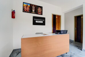 A reception desk with a sign indicating it's a townhouse and serviced by OYO.