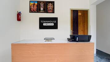 A reception desk with a sign indicating it is serviced by OYO.