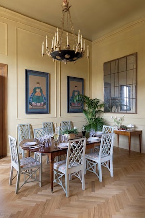 A dining room with a chandelier, wooden dining table, white chairs, and framed artwork on the walls. - Apartment in Florence with 5 bedrooms sleeps 10 (Florence)