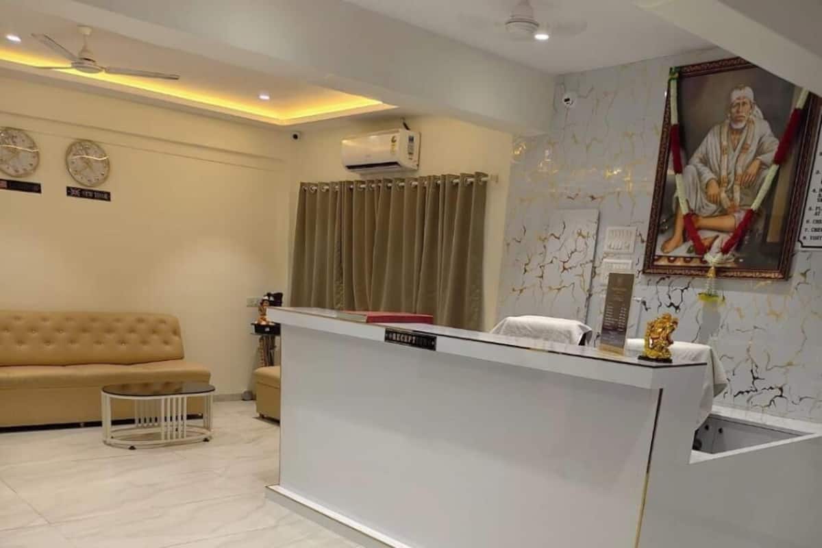 A reception area with a reception desk, a sofa, a small table, and a wall-mounted clock.