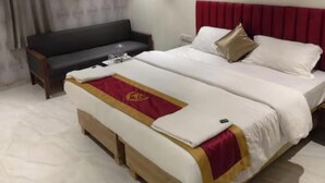 Ein Hotelzimmer mit Bett, Sofa, Deckenventilator und Klimaanlage.