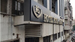 Ein Gebäude mit einem Schild für 'HOTEL ROYAL GALAXY', das ein Kronen-Emblem und einen Lorbeerkranz zeigt.