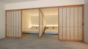 A room with a sliding shoji screen door, a bed with a headboard, and a bedside table.