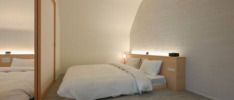 A hotel room with two beds, wooden headboards, and a large wall with a textured surface.