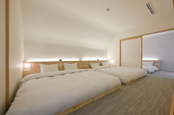 A hotel room with two beds, a wooden headboard, a large mirror, and a carpeted floor. - JINRYU HOTEL ISE (Ise)