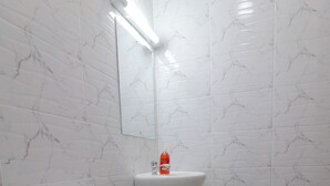 Et badeværelse med toilet, håndvask og spejl.