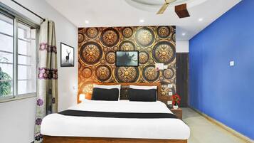 A bedroom with a bed, a ceiling fan, patterned wallpaper, and a blue wall.