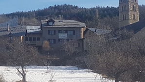 A building with a steep roof and a tower with a pointed roof. - LA MAISON DE JOSEPHINE  (Risoul)