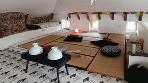 Un acogedor loft con pared de piedra, un sofá, una lámpara colgante y una mesita baja con adornos.