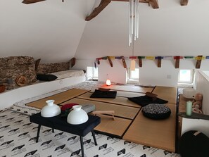 Ein gemütliches Loft-Zimmer mit Steinsturz, einer Couch, einer hängenden Leuchte und einem Tisch mit Dekorationsobjekten.