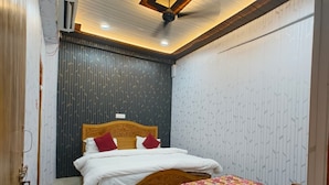 Un dormitorio con cama, cabecera de madera, ventilador de techo y pared con diseño.