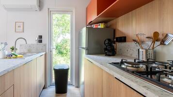 Coffee/tea maker, fridge, stovetop, cookware/dishes/utensils