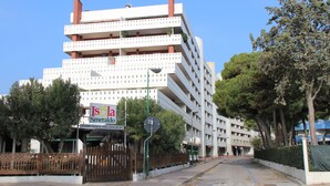 A multi-story building with balconies, a sign for 'Isola Smeraldo,' and a gated entrance. - Bright flat only 150mt from the beach (Lignano Sabbiadoro)