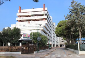 A multi-story building with balconies, a sign for 'Isola Smeraldo,' and a gated entrance. - Bright flat only 150mt from the beach (Lignano Sabbiadoro)